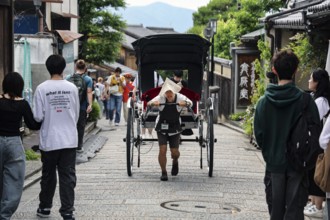 Rickshaw on busy Sannenzaka street surrounded by tourists, Kyoto, Higashiyama, Japan