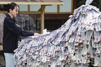 Woman at Yasui Konpira-gu temple looking at stone with wishes, Gion, Kyoto, Japan