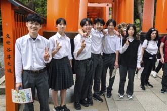 Students pose in front of torii at Fushimi Inari Shrine in Kyoto, Fushimi, Kyoto, Japan