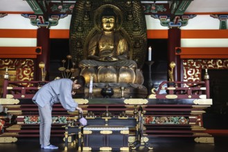 Woman cleaning a magnificent Buddha temple altar, Kyoto, Higashiyama, Japan
