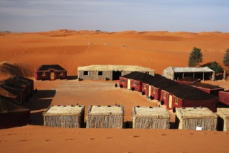Desert camp in Erg Chebbi with tents and huts in a sandy desert landscape, Erg Chebbi, Morocco