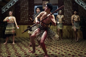 Maori warrior dancing with a spear in a tribal house, Rotorua, Te Puia, New Zealand