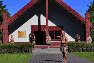 Maori group performs a welcoming ceremony in front of a traditional marae in Rotorua, Rotorua, Bay