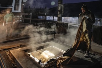 Preparation of a traditional hangi at night in Rotorua with a steaming pit, Rotorua, Bay of Plenty,
