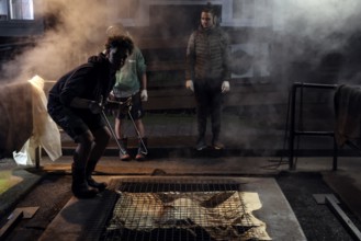 People prepare a traditional hangi in a steaming earth pit in Rotorua, Rotorua, Bay of Plenty, New