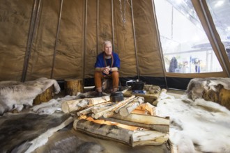 A person is sitting in a teepee at the Norwegian stand at the Green Week at the exhibition center