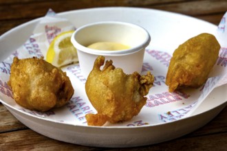 Fried oysters on a plate with lemon and dip at Wynard Quarter Fish Market, Auckland, North Island,
