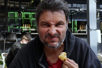 Man tries fried oysters at Wynard Quarter fish market in Auckland, Auckland, North Island, New