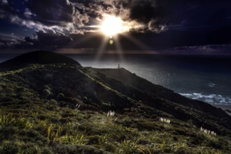 Darkness and sun rays at Cape Reinga with the lighthouse in the foreground, Cape Reinga, Northland,