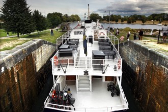 A ship passes the lock on the Göta Canal in Berg, surrounded by nature and clouds, Berg,