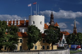Historic castle with red roof on the Düna in Riga surrounded by trees, Riga, Vidzeme, Latvia
