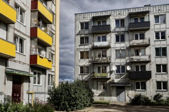 Two-tone prefabricated building with colorful balconies and clouds in the sky, Liepaja, Karosta,