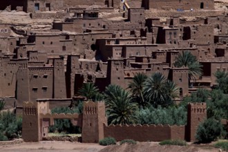 Ait Benhaddou with palm trees in front of the impressive clay architecture, Ait Benhaddou,