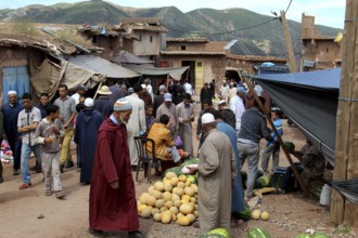 Market scene with people buying or selling melons with mountains in Achaouikh, Achaouikh, Morocco