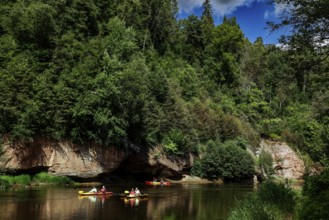 Lined river in Gauja National Park with canoe and steep rocks in the background, Gauja National