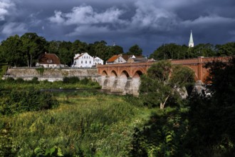 Historic brick bridge across the Venta near Kuldiga, surrounded by lush vegetation, Kuldiga,