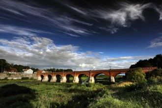 Impressive brick bridge in the Windau valley under a cloudy sky, Kuldiga, Windau, Latvia