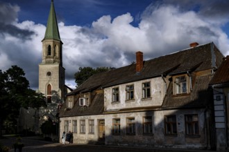 St. Catherine's Church and old houses under dramatic skies in the old town, Kuldiga, Latvia