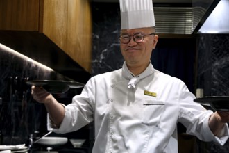 Chef with cap serves soup smiling at Kobe Plaisir restaurant, Kobe, Hyogo, Japan