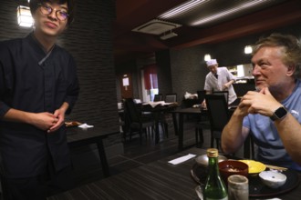 Guest is served by a waiter at a kaiseki restaurant, Kyoto, Okazaki, Japan