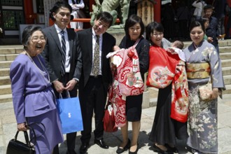 Family with newborn baby celebrating in traditional dress shrine, Kobe, Hyogo, Japan