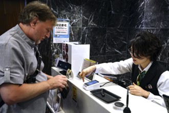 Man pays at the cash register in a restaurant, Kobe, Japan