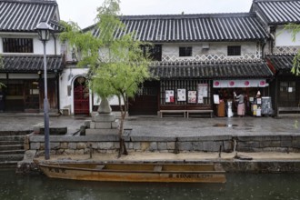 Traditional buildings along a canal in Kurashiki with a small boat in the foreground, Kurashiki,