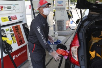 An employee at a gas station in Kyoto refuels a car, Kyoto, Kyoto, Japan