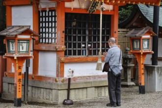 Man praying at a Shinto shrine in Kyoto, Kyoto, Higashiyama, Japan