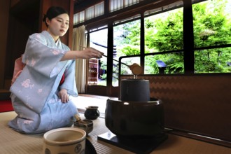 Tea master pouring water into tea kettle during tea ceremony, Kyoto, Higashiyama, Japan