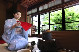 Tea master with red towels at tea ceremony, looking outside, Kyoto, Higashiyama, Japan