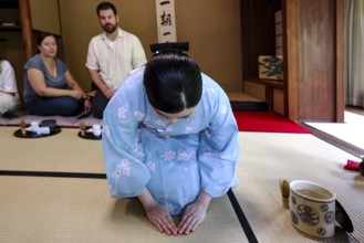 Tea master bows during tea ceremony, guests watching, Kyoto, Higashiyama, Japan