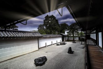 Zen garden with textured sand patterns and rocks surrounded by traditional Japanese architecture,