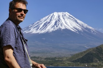 Person looking at Mount Fujiyama across Motosuko Lake, Fujikawaguchiko, Yamanashi, Japan