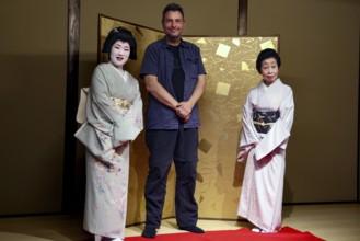 Two geishas and a man pose in the Nishi Chaya tea house district in Kanazawa, Kanazawa, Ishikawa,