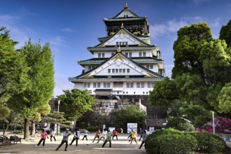 People practice tai chi in front of Osaka Castle, Osaka, Japan