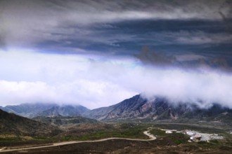 Far-reaching view of mountains and volcanic craters under dramatic cloud formation, Aso, Kumamoto,