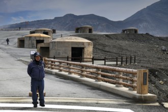 A bunker and rangers stand in the dramatic volcanic landscape of Nakadake, Aso, Aso, Kyushu, Japan
