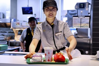 McDonald's employee in Beppu serves a tray of fast food and drinks, Beppu, Oita, Japan