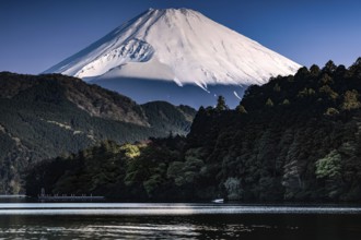 Fujiyama rises majestically over tranquil Lake Ashinoko in bright skies, Hakone, Japan