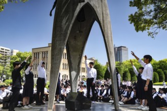 Students stand at a ceremony at the Peace Monument in Hiroshima Peace Park, Hiroshima, Japan