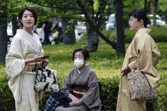 Three woman wearing traditional kimono in the park in Himeji, one wearing a mask, Himeji, Hyogo,