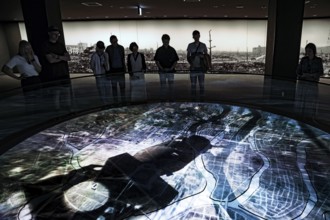 Visitors view a city model with atomic bomb simulation at the Hiroshima Peace Museum, Hiroshima,