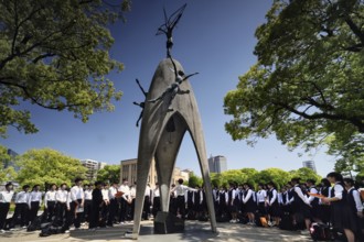 Students gather around the peace monument in Hiroshima Peace Park, Hiroshima, Japan