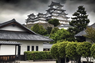 View of the iconic Himeji Castle and surrounding buildings dramatically reinforced by clouds,