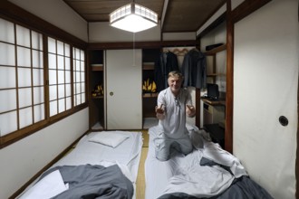Japanese room with tatami flooring and futons. Guest preparing for overnight stay, Beppu, Oita,