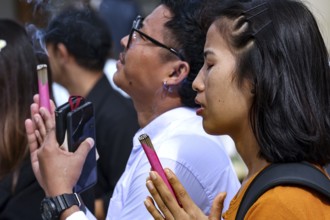 People pray with their eyes closed at the Big Buddha in Kotokuin Temple, Kamakura, Japan