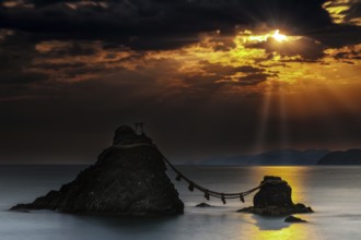 Married rocks at sunrise symbolized by a rope that connects them, Ise, Japan