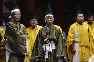 Shinto priest in festive dress wearing traditional hats in the courtyard of Toshogu Shrine, Nikko,