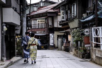 People in Yukata stroll down a traditional street in Yamanouchi, Yamanouchi, Nagano, Japan